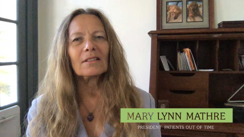 Mary Lynn Mathre, President of Patients Out of Time, with long wavy hair indoors.